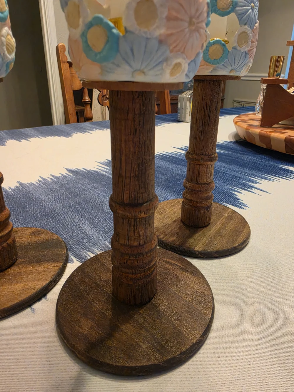 Trio Of Turned dark wood candlestick holders pastel-colored sculpted floral cups